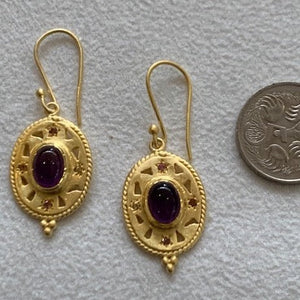 Gold with amethyst stone in the centre.
